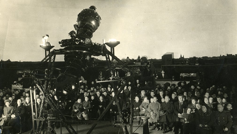 Лекция в старом планетарии. Виден лектор и кафедра.                             Открытый источник.