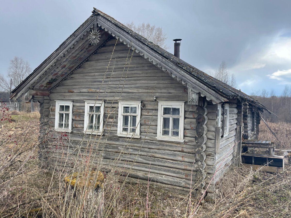 Старинная изба. Характерный штрих-резные причелины и оберег-полотенце в виде солярного знака, охранявший  обитателей от злых сил, но бесполезный против эффективных управленцев. Фото автора. Весна 2023