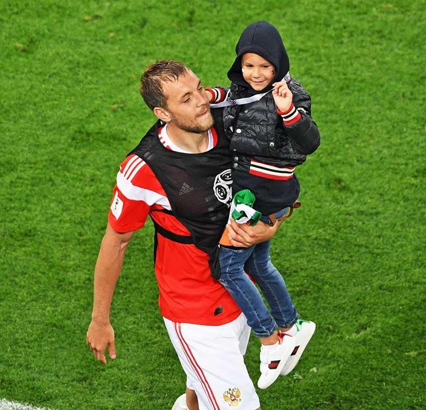 НА ЧМ-2018 В МАТЧЕ СО СБОРНОЙ ЕГИПТА ОДИН ИЗ ГОЛОВ ЗАБИЛ АРТЕМ. ПОСЛЕ ИГРЫ СЧАСТЛИВЫЙ ФУТБОЛИСТ ВЫШЕЛ НА ПОЛЕ СО СТАРШИМ СЫНОМ НИКИТОЙ. ФОТО: АЛЕКСЕЙ ФИЛИППОВ/РИА НОВОСТИ 