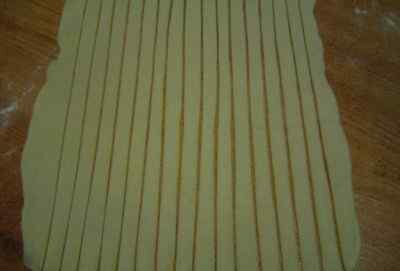 Тесто раскатать тонко и нарезать полосками, шириной примерно по 2 см.