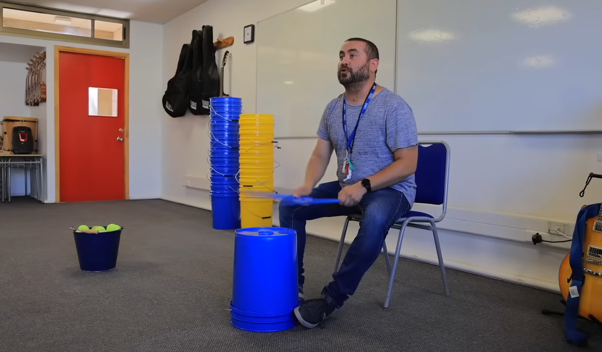 Учитель музыки показывает как бить палками по ведру