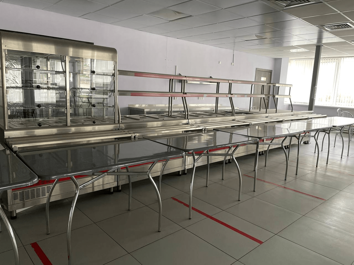 Пустые столы в бывшем помещении столовой