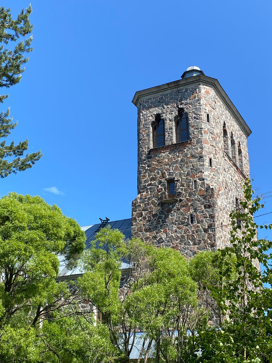 Вид на кирху, утопающую в летней зелени