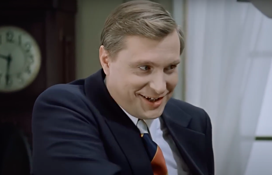 У Самохвалова дружелюбный вид, улыбка на лице. Кадр из фильма "Служебный роман". 