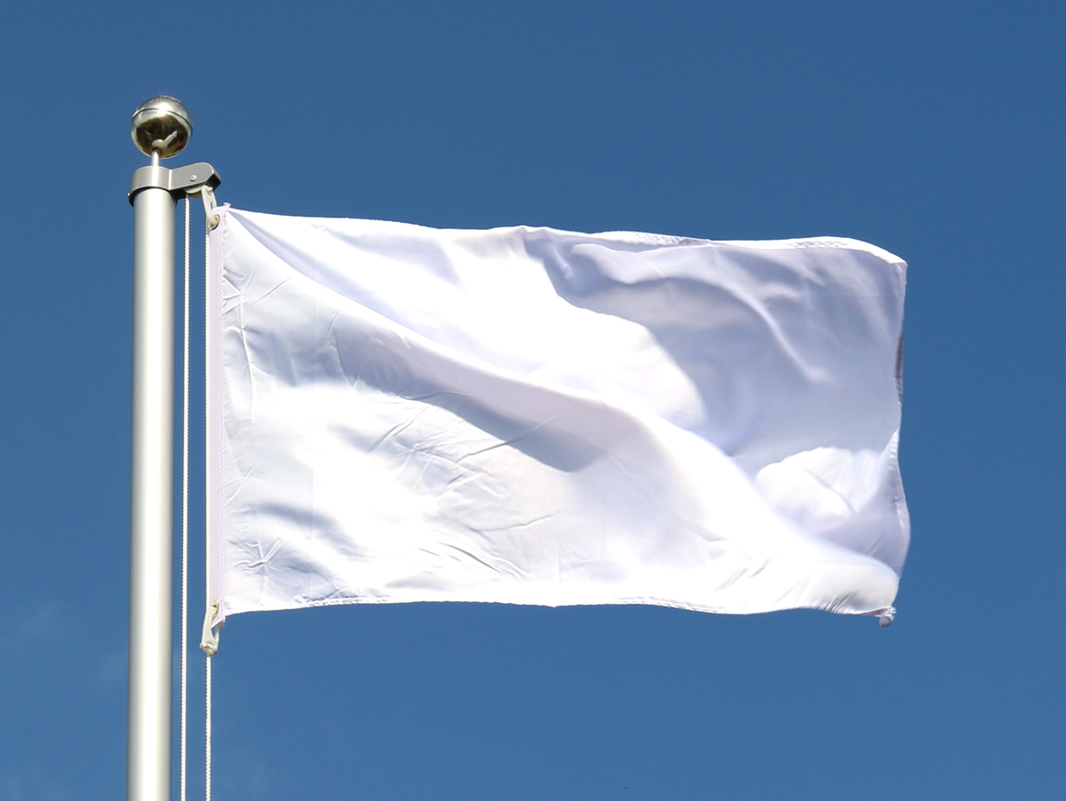 White flag waving in the wind on flagpole against the sky with clouds on sunny d