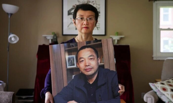 Софи Луо Шэнчунь, жена заключённого в тюрьму китайского адвоката по правам человека Дин Цзяси, с его фотографией в её доме в Альфреде, Нью-Йорк, 28 июля 2022 года. (Brendan McDermid/Reuters)