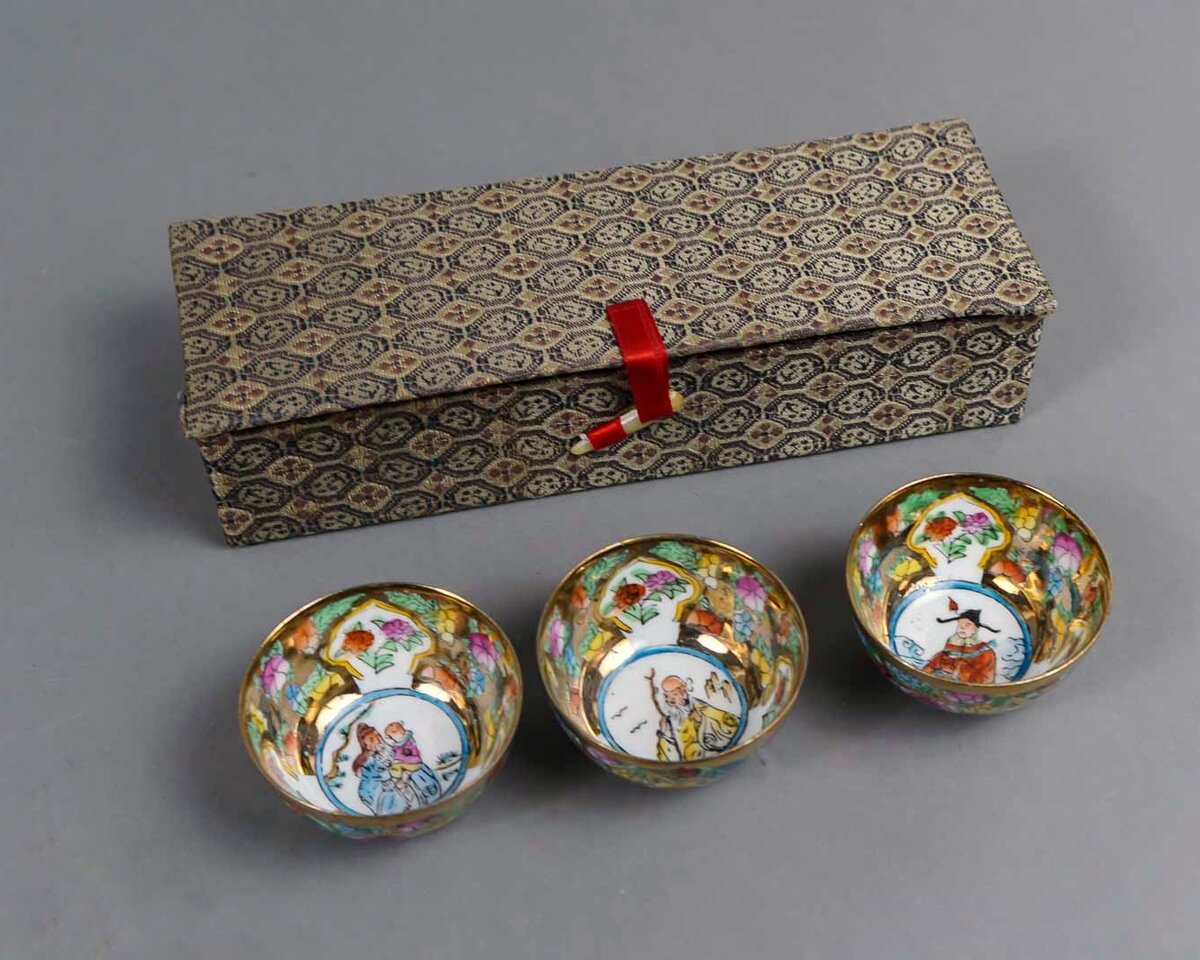 Набор для саке в коробке. 2-я пол. 20 в. Фарфор, ручная эмалевая роспись, (на дне разные сюжеты), золочение. Диаметр 4.7 см, высота 2.3 см. https://ru.bidspirit.com