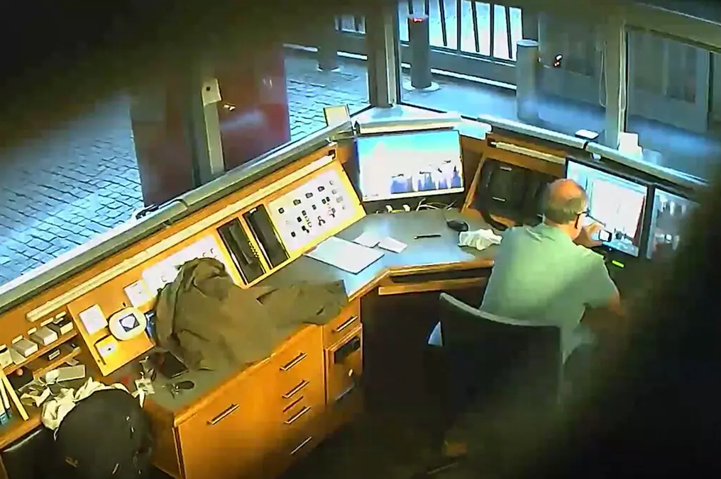 На раздаточном изображении, выпущенном столичной полицией, показан кадр со скрытой камеры, на котором Дэвид Смит снимает видео с мониторов системы видеонаблюдения в киоске охраны посольства Великобритании в Берлине в 2021 году. Позже он был арестован и обвинён в шпионаже в пользу России [лично я вижу, как мужик что-то снимает на телефон. Не уверен, что шпионский умысле был доказан. По-моему, максимум, что можно здесь предъявить — халатность при соблюдении режима секретности —  прим. «МП»] © Metropolitan Police, via Agence France-Presse - Getty Images