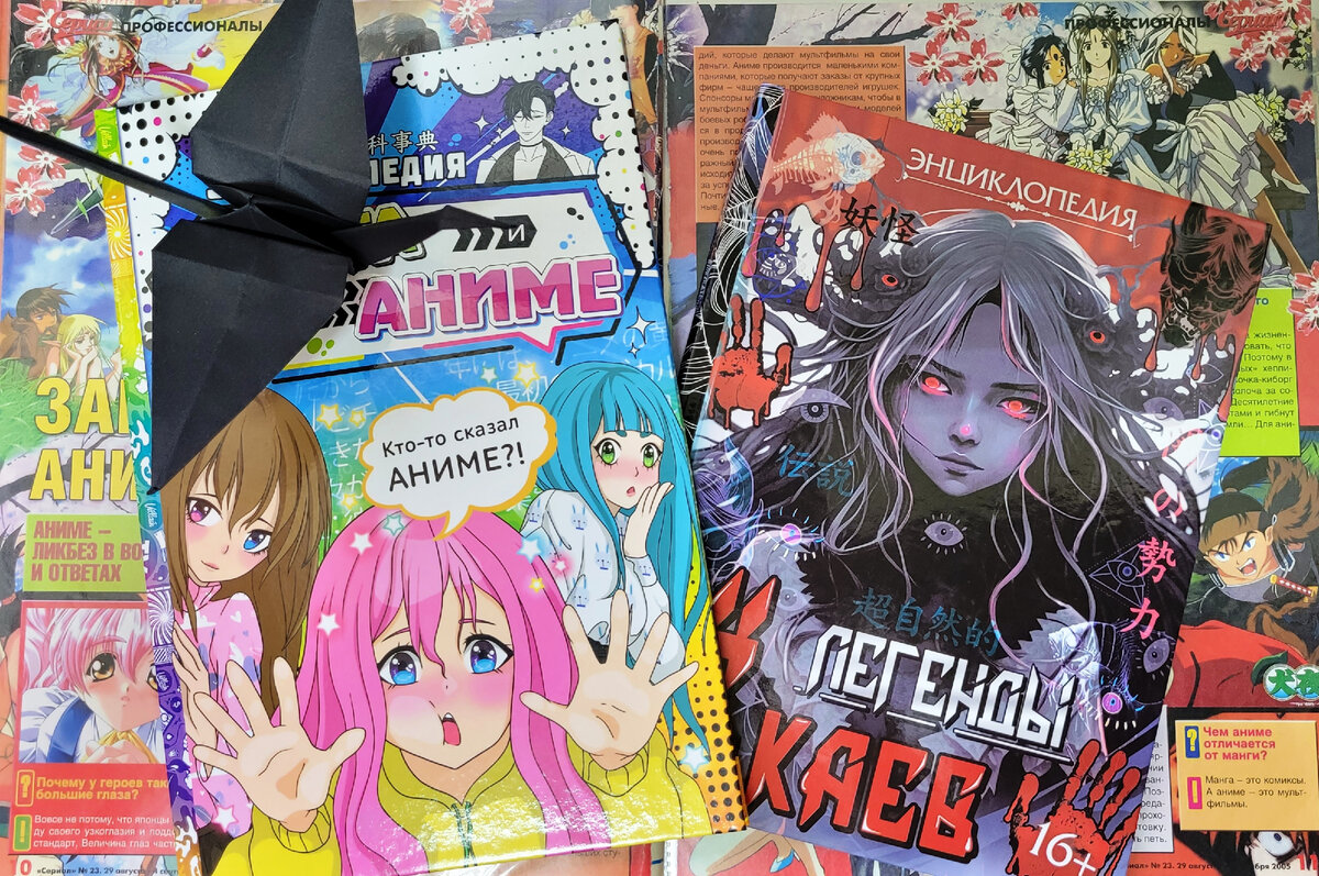 Фото из моей личной коллекции. Публикация фото преследует в информационные цели. На фото: 2 энциклопедии автора Пьянковой Олеси, издание sima-land, Буква Ленд - "Энциклопедия Манга и Аниме. Путешествие во времени" и "Легенды Ёкаев",  разворот из папки с вырезками из разных журналов, которые бережно сохранены подписчиком "The finds bureau", журавлик (черный) тоже от данного подписчика. 