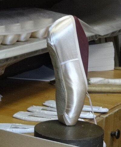 В таком виде продаются пуанты - жесткая обувь балерины. На них нет ни лент, ни резинок, которые бы удержали стопу балерины. Пуанты требуют особого внимания балерины, потому что после покупки она готовит их к беспощадной работе стоп.