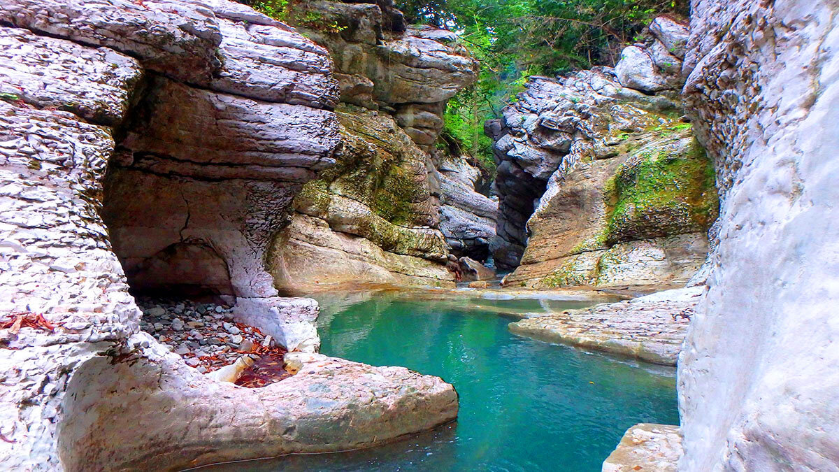 Не так давно, когда все мы были маленькими ,мы смотрели фильмы про будущее где люди беспрепятственно путешествует по миру или даже к далеким звездам.  И мы мечтали что когда станем старше   то сможем повторить подвиги таких полюбившихся нам киногероев как Индиана Джонс... Но повзрослев мы столкнулись с суровой реальности бытия, и в большинстве своём могли себе позволить лишь отдых в  Сочи. И в данной статье я хочу  у вас познакомиться с интересными местами которых вы вряд ли слышали с удовольствием захотите побывать. И не волнуйтесь статья будет с картиками) Начнем с того что я хочу вас предупредить в некоторые места пускают не просто так.Для прохода(проезда) нужен комплект документов ,который я объясню где и как получать без особого труда. Начну пожалуй с моего любимого места под названием Мамонтово ущелье.
Данный природный объект находится в районе населенного пункта Ермоловка. Чтобы попасть туда нужно оформить пропуск в пограничную зону потому что находится ущелье непосредственно вблизи от государственной границы с республикой Абхазия. Если вы приехали на одну две недели то советую вам оформить данный пропуск через сайт Госуслуги. Пропуск делается по времени 1-2 недели максимум. Поэтому советую вам заранее оформить все документы через данный сайт.{ссылка на сайт}.Без пропуска вас не пропустят в пограничную зону,и могут объявить административный штраф.
А теперь расскажу о самом ущелье. Побывав там у вас останутся неизгладимое впечатление множество положительных эмоций. Это довольно интересное место для отдыха как взрослому человеку так и детям.  сама ущелье представляет из себя не Большой Каньон с природными горками и чашами у  подножья. Эдакий природный аквапарк)
В самом низу в начале ущелья есть небольшие  беседки под навесом  а немного дальше стоит оборудованное место для прожарки мяса.Для тех кто любит шашлыки. Не так давно в буквально в 2015 году  собирались  экскурсии на джипах  , для поездки на Мамонтово ущелье,дабы показать туристам насколько красива природа в Сочи.
Перед въездом на Мамонтово ущелье вы увидите дорогу вверх. Она ведет к месту которая стоит своего названия Это место называется Сказочный каньон и это поистине сказочное место.
В сезон дождей уровень воды поднимается до самого верха однако уже совсем скоро уровень воды опускается, это как раз  тот самый момент когда можно попрыгать со скал в воду . Эти развлечения принесут бурю положительных эмоций. Однако не стоит забывать о технике безопасности при прыжках в воду))
В самом Сказочном Каньоне есть небольшое кафе. Его хозяин один из местных жителей. Он как хороший хозяин всегда угостит свежим шашлыком и очень хорошим домашним вином собственного производства.
Спасибо что дочитали данную статью до конца  и надеюсь что вы нашли для себя нужную вам информацию.
