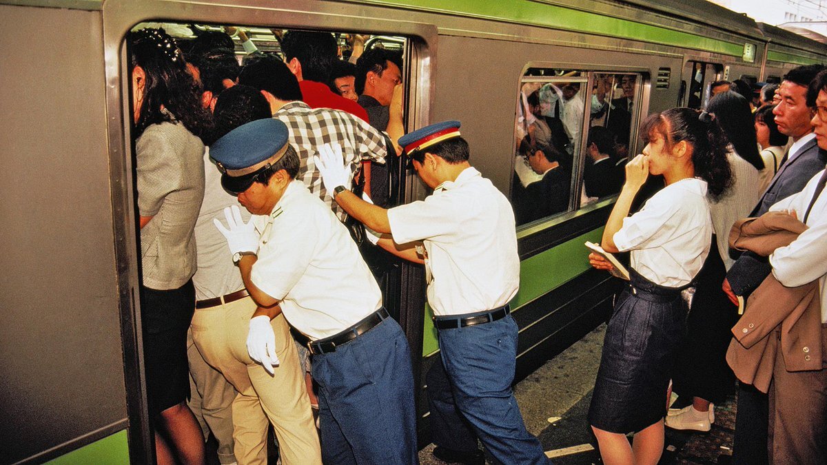 Трамбовщик пассажиров в метро в Японии