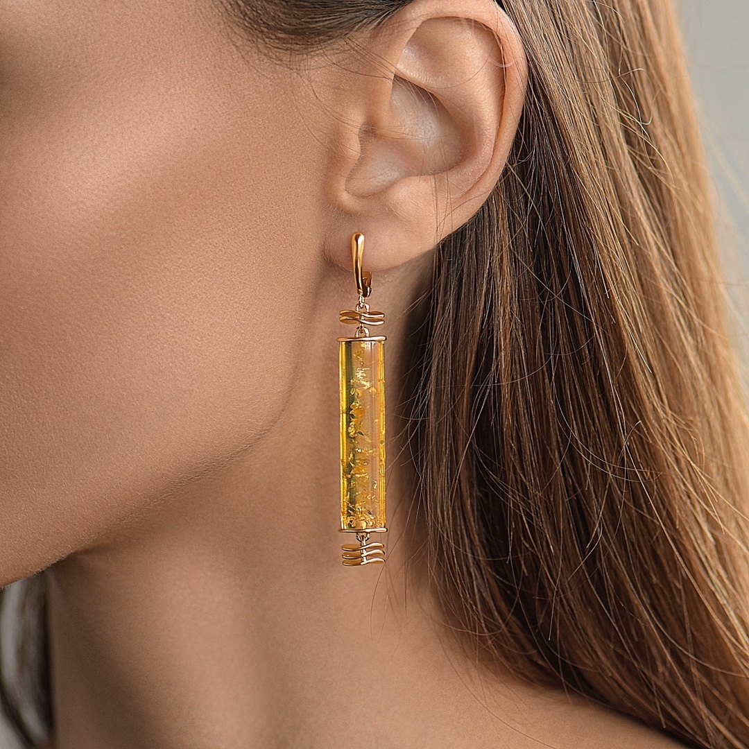 На фото серьги с крупным янтарем и изящной позолотой.