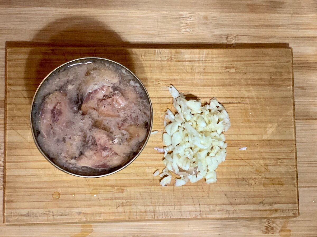 Подготовка продуктов. Банка сардин в масле и порезанный чеснок для обжарки в масле. Фото автора.