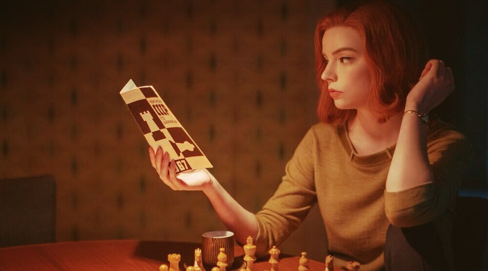 Девушка читает шахматную книгу