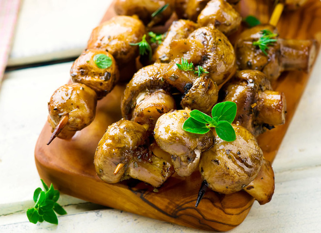 Готовый шашлык из шампиньонов подан на доске