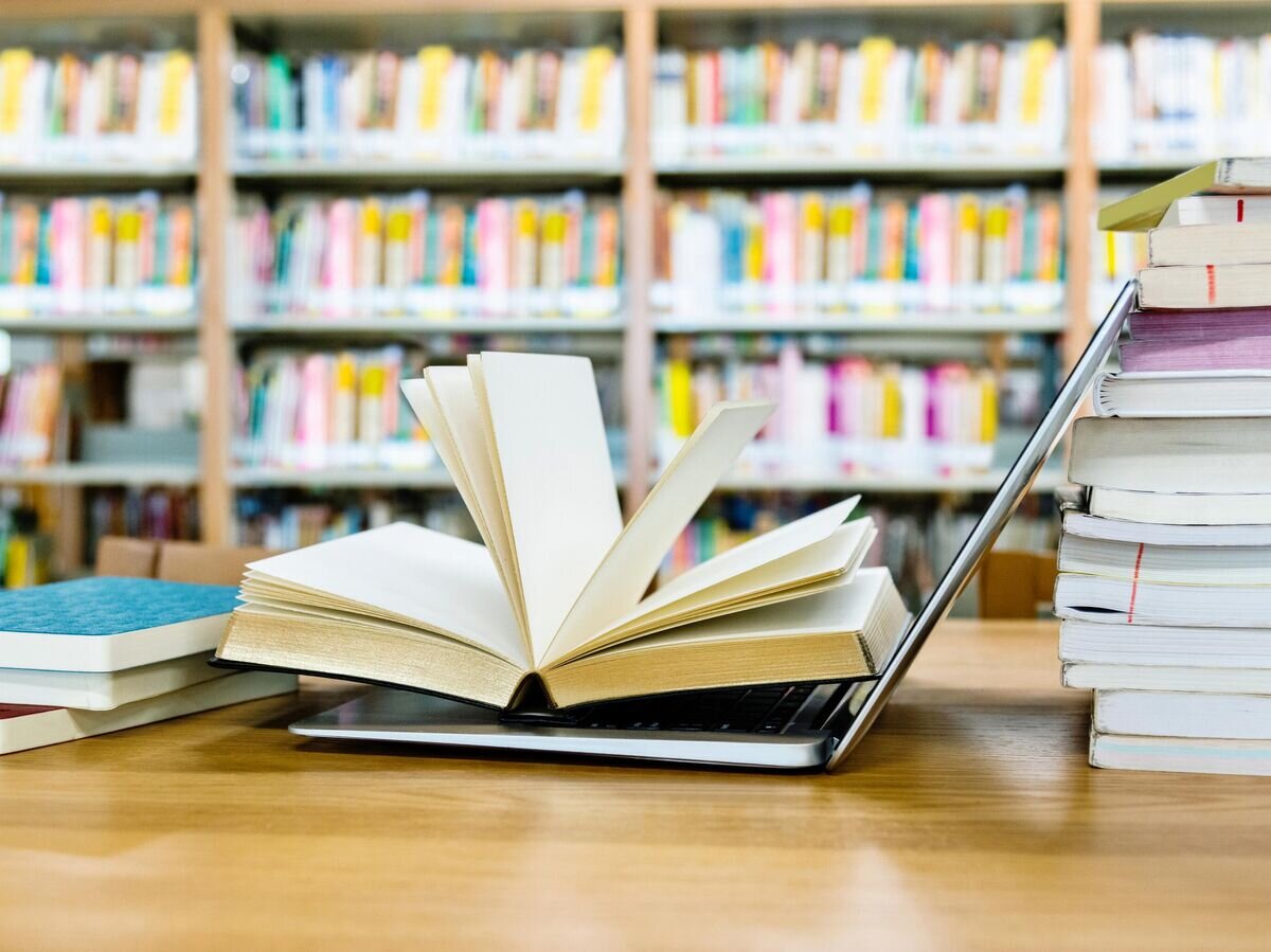    Открытая книга на ноутбуке© iStock.com / baona
