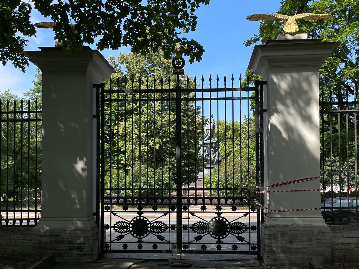 Через ажурные ворота сада Аничкова дворца видим памятник Екатерине II в Екатерининском саду, расположенном напротив