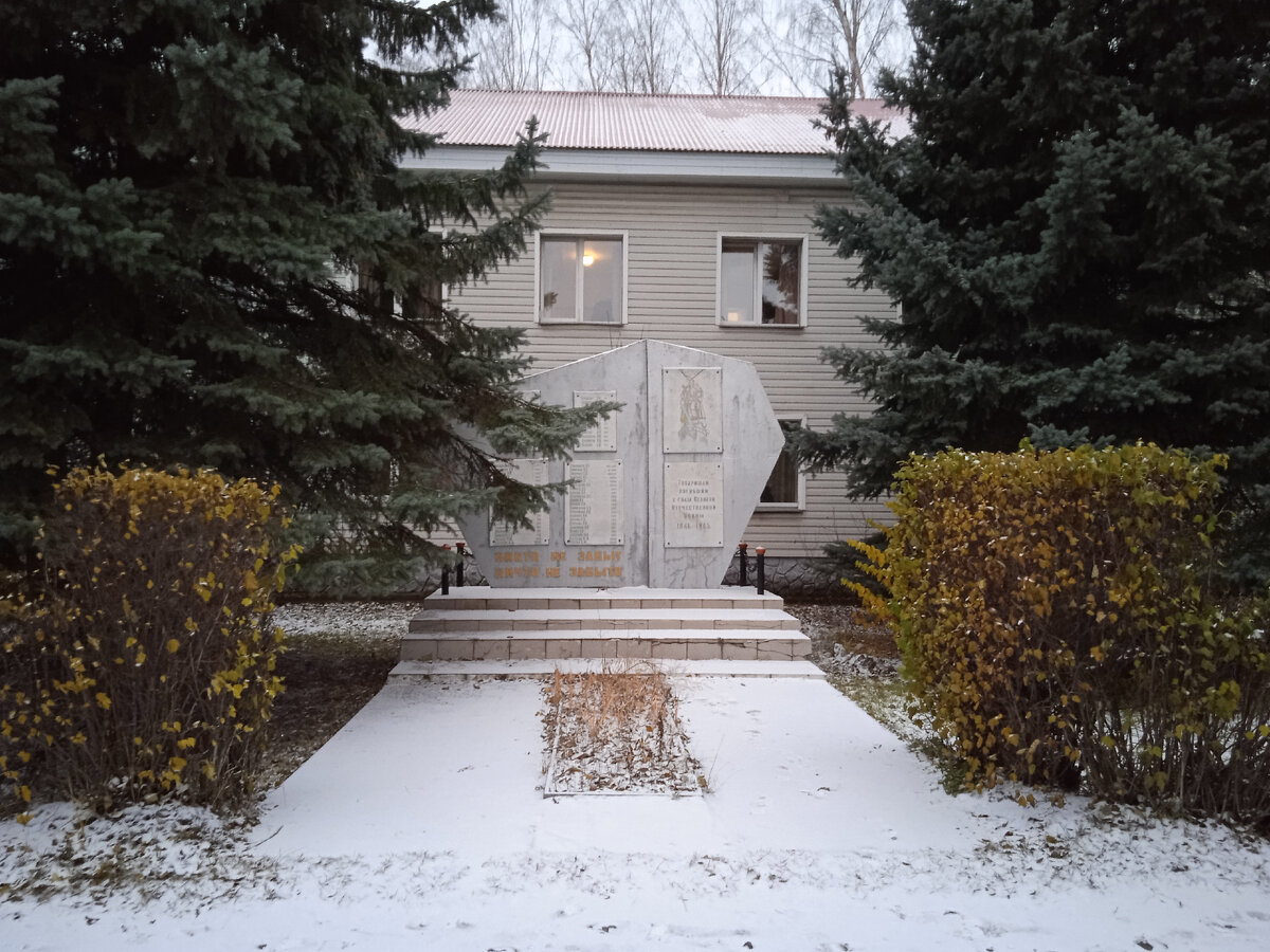 Между елями и кустарниками находится мемориал. Фото автора.