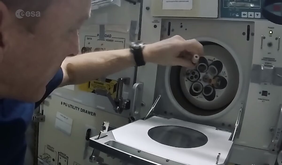 Тим Пик помещает колбы в центрифугу
