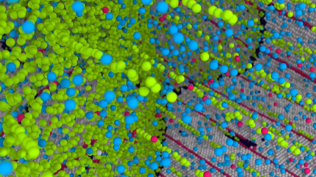 Атомы меди (показаны зелёным), расположенные вдоль границ зёрен (снизу) и внутри дефектов структуры (длинные нити, идущие вверх). 