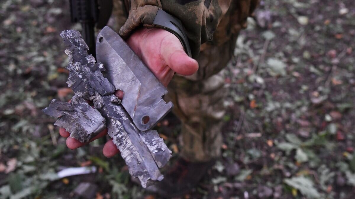    Боец демонстрирует осколки боеприпаса иностранного производства, выпущенного артиллерией ВСУ, на передовой на окраине Красного Лимана в ДНР© РИА Новости / Виктор Антонюк