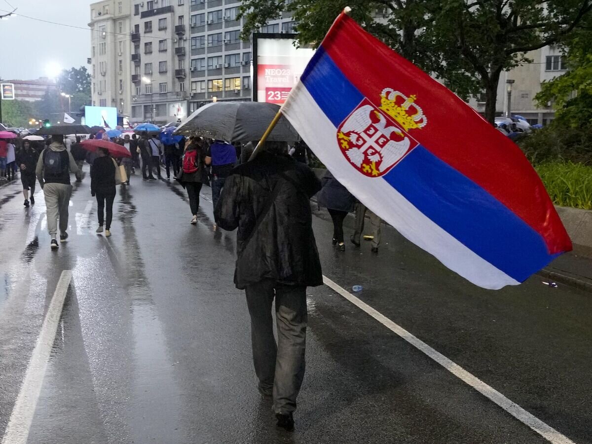 Мужчина держит сербский флаг© AP Photo / Darko Vojinovic