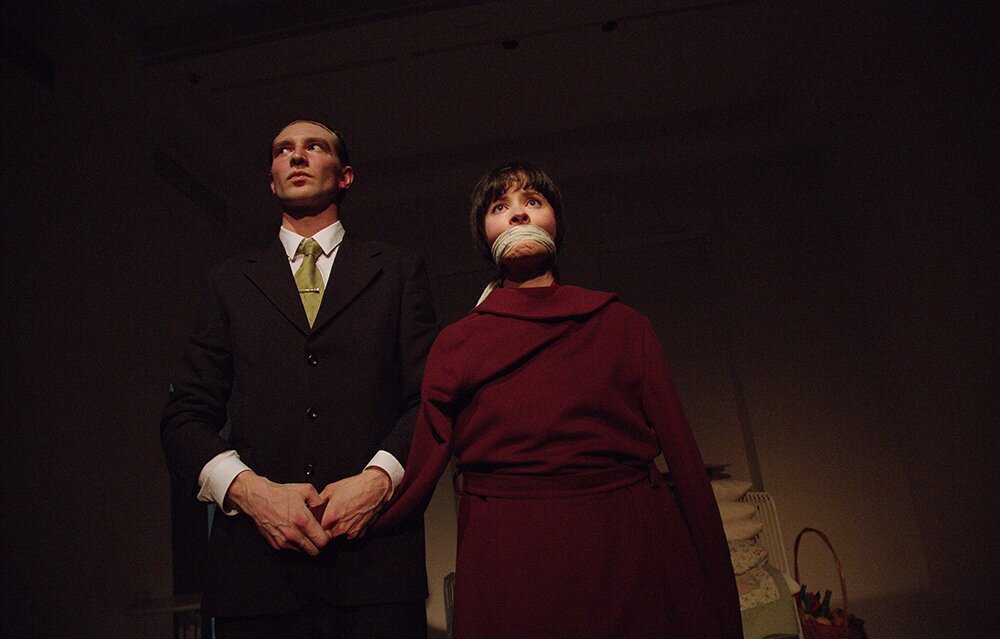 Наверняка многие читали самый первый и, пожалуй, самый знаменитый роман Джона Фаулза "Коллекционер", да и его экранизацию, получившую самые престижные награды и номинированную на Оскар, тоже смотрели. Что к этому еще можно добавить и зачем ставить спектакль, думала я, собираясь в Московский Театр Юного Зрителя. Но театральное искусство это все-таки отдельная тема. Здесь спектакль, как феникс, рождается у нас на глазах. Здесь мы, зрители, не менее важны, чем режиссер и актеры. И при каждом просмотре это будет новый спектакль, может лучше или хуже, чем предыдущий, но в чем-то неуловимо другой.  Сцена "Игры во флигеле" очень подходит для "Коллекционера": замкнутое, крохотное, абсолютно белое пространство. Глазу не за что зацепиться. Подвал-тюрьма. Заприте меня здесь и клаустрофобия обеспечена.
Два актера Он и Она. Коллекционер Фредерик (Олег Ребров) и его заключенная Миранда (Марина Ворожищева). Поставил спектакль Павел Артемьев. Я видела в МТЮЗе его "Четвероногую ворону" - очень рекомендую. А теперь случился "Коллекционер". Спектакль идет уже семь лет, но я только до него добралась. Боялась.
Коллекционирование само по себе безобидное хобби. Люди коллекционируют марки, монеты, значки и картины. Многие коллекционируют бабочек и жуков. Но Фредерик, выиграв безумно много денег, переключился с бабочек на коллекционирование людей. Миранда его первый экземпляр. 
История, придуманная Джоном Фаулзом, и поставленная Павлом Артемьевым пугает своей обыденностью, правдивостью и безысходностью. Сразу становится понятно, что все закончится плохо, но зрители сидят как завороженные, даже в антракте никто не уходит. Вот она - волшебная сила искусства.
В романе в равной степени рассказ ведется как от лица Фредерика, так и от лица Миранды. В спектакле заметен явный перекос в сторону Коллекционера. Здесь он главный герой.  Он становится добровольным рабом для жемчужины своей коллекции, окружает ее вниманием, старается покорить своей вежливостью. Фредерик   не позволяет себе грубости и дурных слов. Как только Миранда закипает во власти праведного гнева, он обезоруживает ее почтительностью и обходительностью по отношению к пленнице. Ему достаточно сохранять власть над Мирандой, любоваться ее красотой, слушать ее речи и в то же время совершенно их не понимать.
Коллекционер убеждает Миранду и нас в своих чистых и благих помыслах. Да, он сотворил преступление, но у него в мыслях нет ничего грязного, только высокие и, по его же словам, благие намерения. Но штука в том, что в еще большей степени он старается убедить в этом и самого себя. 
Ужасный ход событий не оставляет шанса на раскаяние, на признание вины и раскрытие страшной тайны. Фредерик абсолютный монстр, лишенный сострадания и чувства вины.
Миранда же полная противоположность своему мучителю. Она проявляет и стойкость, и самообладание в момент осознания, что и как с ней случилось. Естественное ощущение страха сменяется анализом происходящего, изучением ситуации и поиском выхода из нее. Самое главное, что Миранда не теряет саму себя.
Коллекционер не позарился на ее тело, он не просит ее ни о чем недозволенном, он даже боится прикоснуться к ней. От этого негодование Миранды вспыхивает с большей силой. Что ему нужно?
Миранда похожа на бабочку, которая попала в сачок, а затем и в стеклянный сосуд коллекционера. Сначала он с ней ничего не делает, просто любуется, а бабочка все бьется и бьется о стекло в попытке вырваться на свободу. А потом насекомое засыпает вечным сном, наколотое на булавку.
Так и попавшая в плен девушка проходит все ступени мучений бабочки, и пугает в спектакле больше всего то, что здесь жизнь человека низведена до жизни насекомого. 
В финале становится понятно, что Миранда не последняя жертва Фредерика: Коллекционер выходит на охоту.
