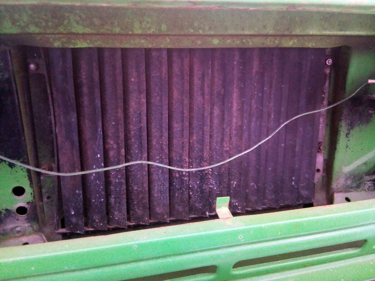 Жалюзи почти закрыты, видны четыре точки крепления. Видно грязь на шторках, которая не попадает в радиатор и на мотор.