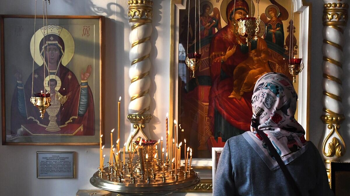    Верующая в храме Успения Божией Матери© РИА Новости / Виталий Аньков