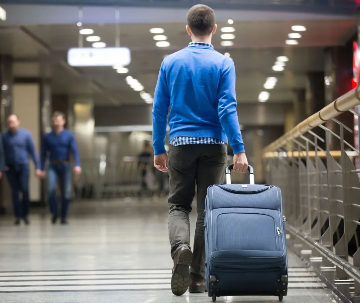 Сын переезжает в другой город. Люди с чемоданами в аэропорту. Человек с чемоданом. Мужчина с чемоданом. Мужчина в аэропорту.