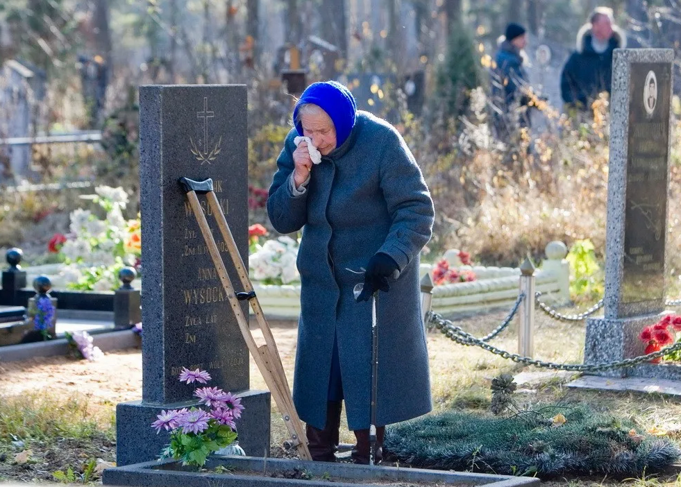 Что говорят вдовы. Бабушка на кладбище. Старушка у могилы на кладбище.