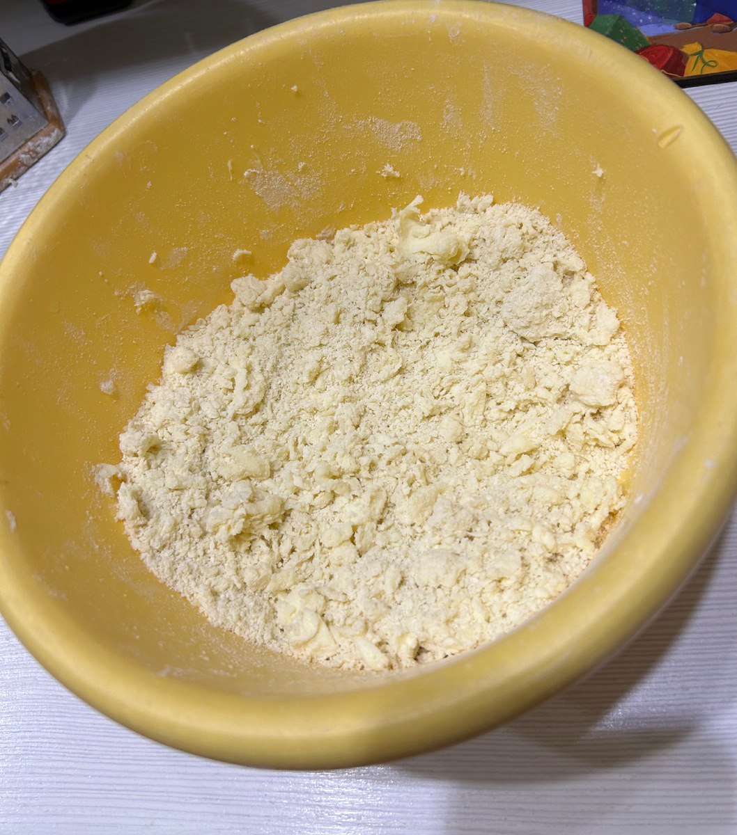 Масло из холодильника обваливаем в муке и трем на терке в миске с мукой