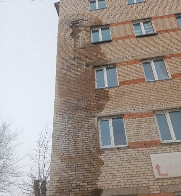    Мокрое пятно расползлось по фасаду здания на четыре этажа