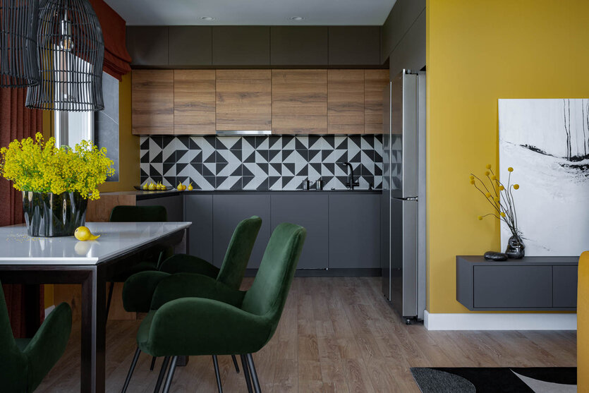 Помимо ярких цветов, в оформлении использованы притягивающие внимание графичные принты (плитка на кухонном фартуке и ковре). Кухня и консоль изготовлены на заказ по эскизам дизайнеров в студии мебели «ВарАлекс».