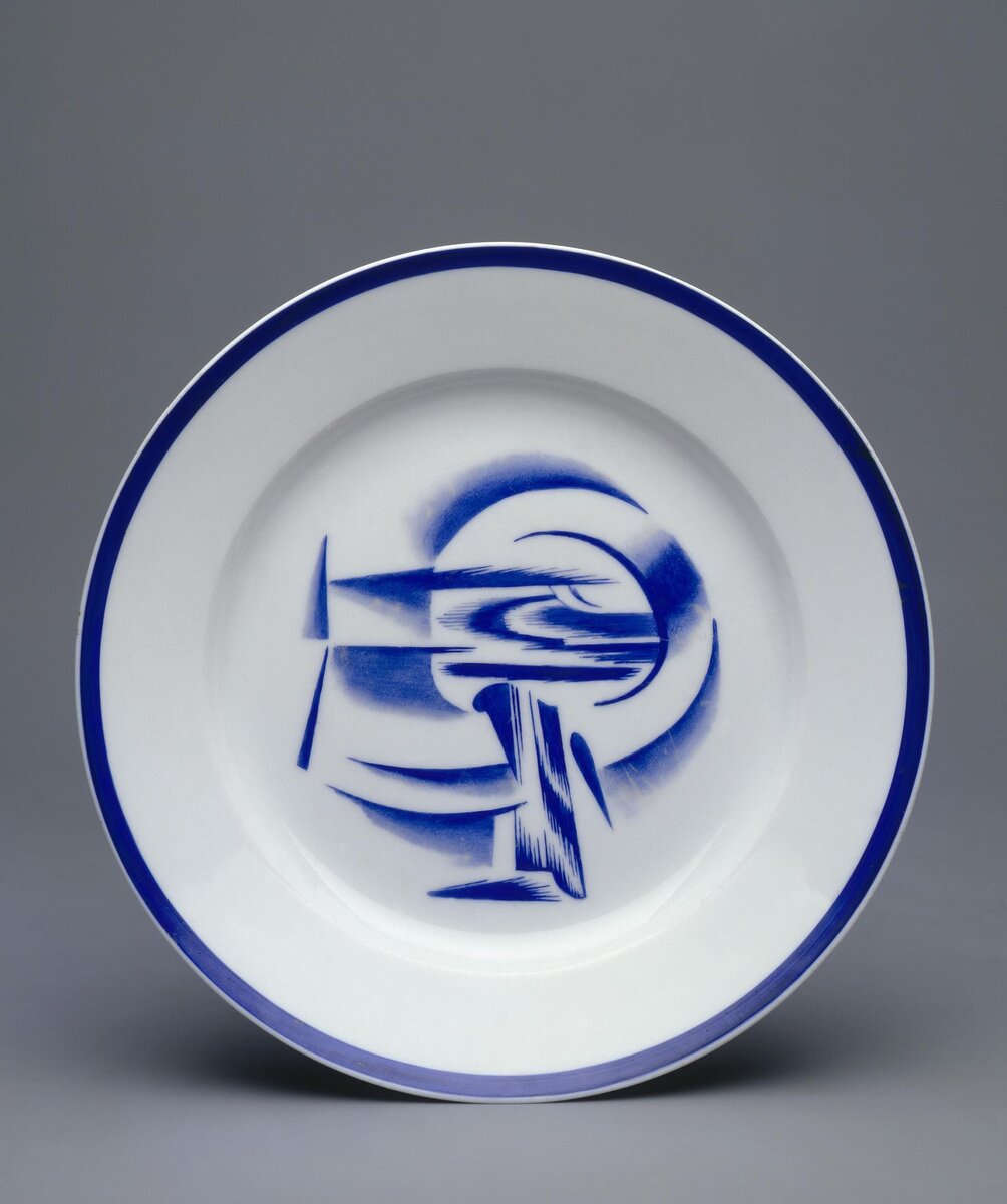 Совершенно ФУТУРИСТИЧЕСКИЙ рисунок. Тарелка "Эмблемы". 1919. Роспись надглазурная монохромная. Размеры: 3,3*22,0 см. Собрание Эрмитажа. Предмет поступил в 2002-м году. Передан в составе коллекции Музея Фарфорового завода. Инв. номер Мз-С-1806. Изображение взято из каталога Эрмитажа. Листайте галерею вправо.