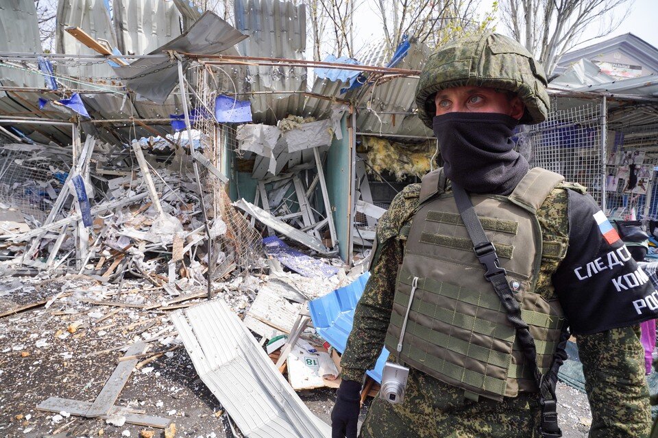     Сотрудник СК РФ на месте обстрела крытого рынка в Донецке. Фото: Николай Тришин/ТАСС