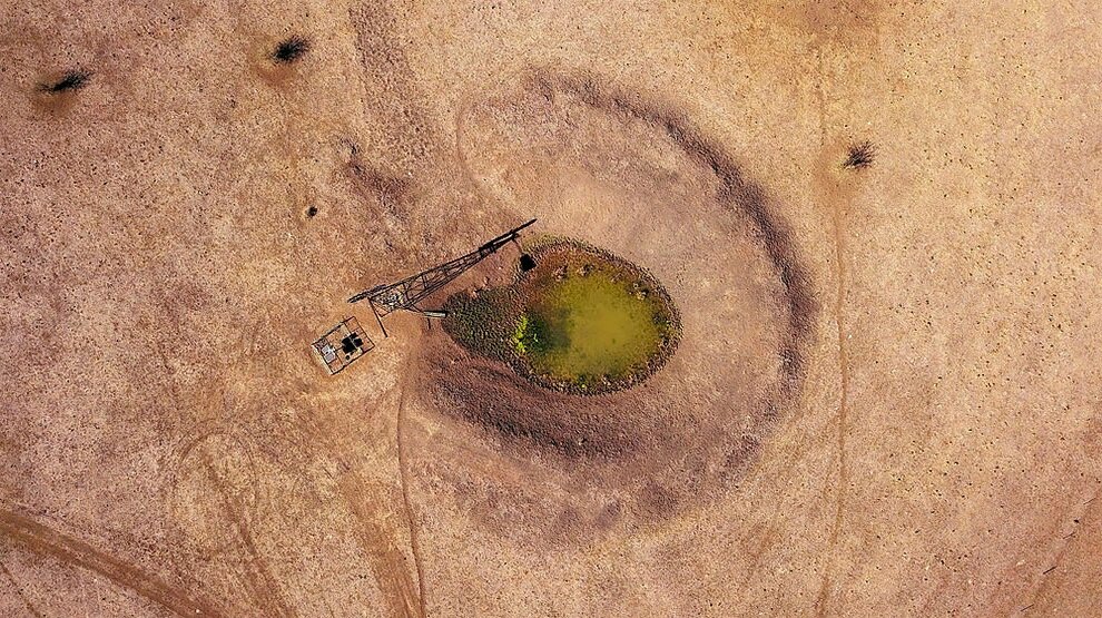 Ветряная мельница и солнечные батареи стоят рядом с плотиной в засушливом районе около имущества фермера Скотта Купера под названием Южный парк. Фото Дэвида Грея, Reuters.