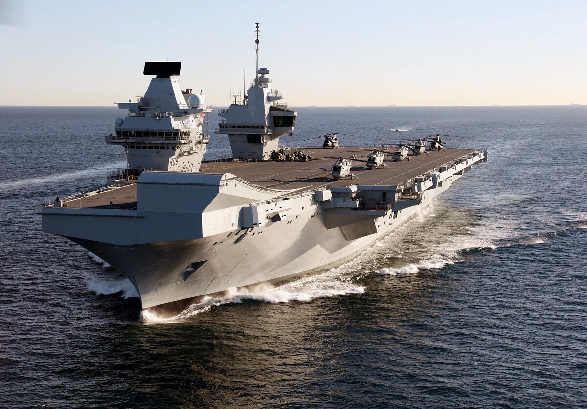 HMS Queen Elizabeth ("Королева Елизавета") - новейший из действующих на сегодняшний день авианосцев (его "близнец" HMS Prince of Wales спущен на воду, но официально еще не принят в строй). Этот британский корабль водоизмещением 65000 тонн несет группировку менее чем в 35 боевых самолетов (+запасные, а также вертолеты и разведчики). Для сравнения, американские авианосцы водоизмещением около 100 тонн имеют на борту более 75 боевых самолетов (+запасные, вертолеты и  разведчики). К слову, американцы принимают сейчас в строй новую серию авианосцев класса Gerald R. Ford: головной корабль уже проходит испытания, второй спускают на воду в этом году, третий строится и еще два готовятся к постройке. Также для сравнения: российский "Адмирал Кузнецев" фактически несет только 14 боевых самолетов, по проекту это число может быть увеличено до 26. (Im. source: Wiki, by Dave Jenkins - InfoGibraltar)