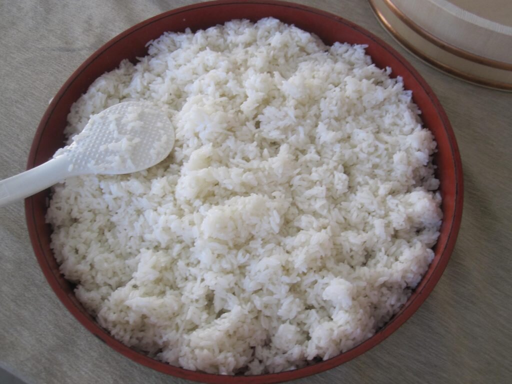 Во многих супермаркетах сейчас продается специальный рис для суши. Он отлично склеивается и не разваривается. В качестве альтернативы рекомендуется приглядеться к обычному крупнозерному кубанскому рису.
Перед тем, как приготовить роллы, рис необходимо хорошо промыть через дуршлаг, чтобы вода стала прозрачной. Варить его нужно в соотношении 1:1 с водой не более 15 минут на среднем огне. Не стоит во время приготовления мешать его и открывать крышку. Для того, чтобы рисинки не пристали к кастрюле, на дно можно застелить фольгу. После варки дать ему немного постоять, накрыв влажным хлопчатобумажным полотенцем. Тогда он не обветриться и начнет равномерно остывать.
