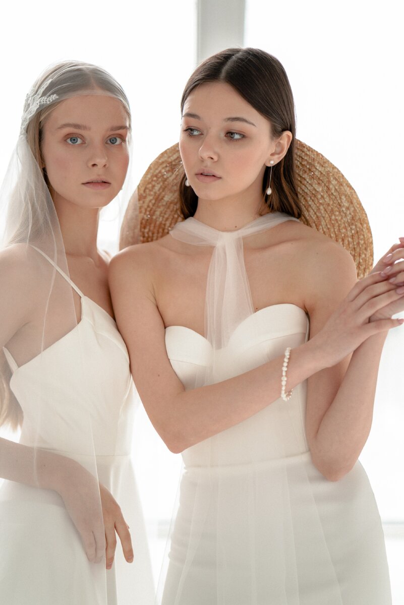 У невесты слева фата из фатина, декорированная кружевом. У невесты справа соломенная шляпа.