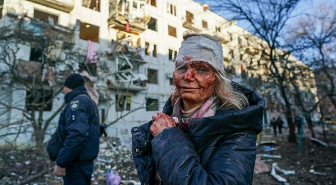 Раненая женщина видна после того, как авиаудар повредил жилой комплекс в городе Чугуев, Харьковская область, Украина, 24 февраля 2022 года.