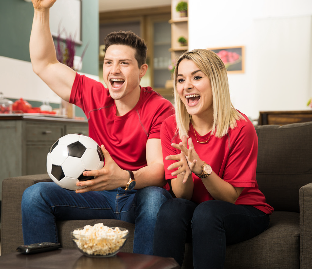 Watch fan. Девушка с футбольным мячом. Женщина смотрит футбол. Мужчина и женщина смотрят футбол. Парень с девушкой смотрят футбол.