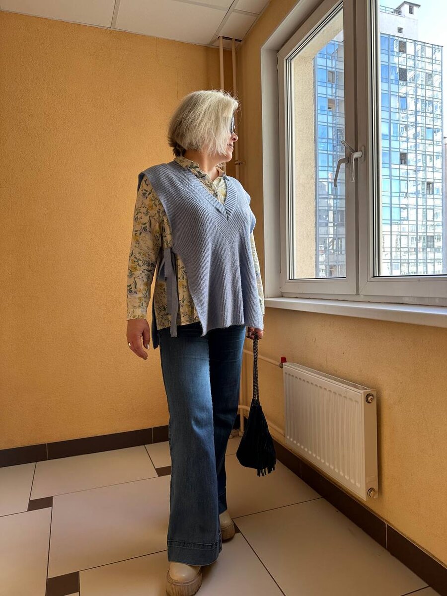 Уютная трикотажная жилетка с блузкой и джинсами.