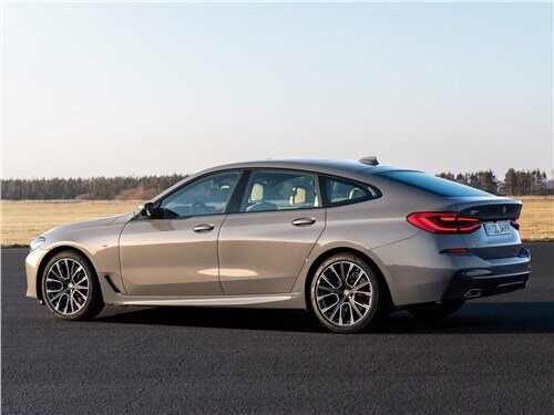 История BMW 6 GT началась в 2017 году. Тогда же первые баварские лифтбеки появились и в России. На лето 2020 года запланирован рестайлинг автомобиля, представленного в нескольких модификациях. После обновления люксовый немец получил более рельефные бампера и несколько иное оформление радиаторной решётки. На него будет устанавливаться совершенно новая передняя оптика. Дверные стёкла избавились от рамок. Авто обрело новый дизайн колёсных дисков, имеющих диаметр 18-20 дюймов. На выбор покупателей будет предложено семь абсолютно новых оттенков кузова. Машина обзавелась спойлером на крышке багажника, который выдвигается автоматически при скорости более 120 км/ч.

В интерьере также заметны изменения. Теперь виртуальная приборная панель будет ставиться по умолчанию, а не за отдельную плату, как было ранее. Появилось новое оборудование и опции. К ним относятся: система удержания в полосе, система автоматического торможения, предупреждение о развязках, автоматическое определение полосы и некоторые другие. Лифтбек обрёл улучшенные передние кресла с множеством настроек, а также обновлённый дизайн рулевого колеса, отделки салона и некоторые иные новшества. Баварец будет оборудоваться шикарным мультимедийным комплексом и акустикой Bowers&Wilkins.

РАЗМЕРЫ
Габариты 6 серии БМВ Гран Туризмо остались после обновления без изменений. Длина – 5091 мм, ширина – 1902 мм, а высота – 1538 мм. Его колёсная база равна 3070 мм, а клиренс – 138 мм. Дорожный просвет лифтбека невелик. Поэтому машина может использоваться лишь по трассе и в городах. Даже незначительное бездорожье или плохая дорога могут стать для неё серьёзной проблемой.

Премиальный автомобиль имеет вместительный багажник объёмом целых 610 литров. Это – очень много для авто такого класса и позволяет перевозить весьма габаритные вещи и предметы. А, если сложить задний диванчик для пассажиров, пространство багажного отсека увеличится до 1800 литров. При том, что баварец не создавался для перевозки грузов, он легко с этим справится при необходимости.

ДВИГАТЕЛЬ И ТРАНСМИССИЯ
Несмотря на то, что в Европе обновлённый BMW 6 GT будет доступен с гибридными силовыми установками, в версиях для российского рынка их пока не предусмотрено. В нашей стране автомобили будут продаваться с бензиновыми и дизельными двигателями. В линейке представлено два мотора, работающих на бензине. Один из них имеет объём 2 литра и мощность 249 лошадиных сил, а второй – объём 3 литра и выдаёт мощность 340 л.с. Дизельных моторов также представлено два. Первый имеет объём 2 л и мощность 190 «лошадей», а второй обладает объёмом 3 л и мощность 249 «кобыл». При впечатляющих скоростных возможностях двигатели отличаются экономичностью и достаточной надёжностью. В смешанном цикле авто с бензиновым ДВС расходуют чуть больше 6 литров на 100 км, а с дизельным – примерно 5 л топлива на сотню. В самых мощных версиях максимальная скорость равна 250 км/ч.

Во всех модификациях баварский лифтбек оснащается лишь автоматической трансмиссией, имеющей восемь ступеней. При этом привод может быть задним или полным. Автомобили с бензиновыми силовыми агрегатами являются заднеприводными, а с дизельными – имеют полный привод.