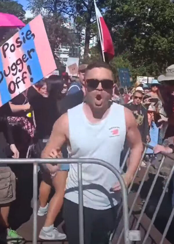 Обезумевшая толпа прорывает ограждения. Искаженные лица и предельно агрессивное поведение толпы.