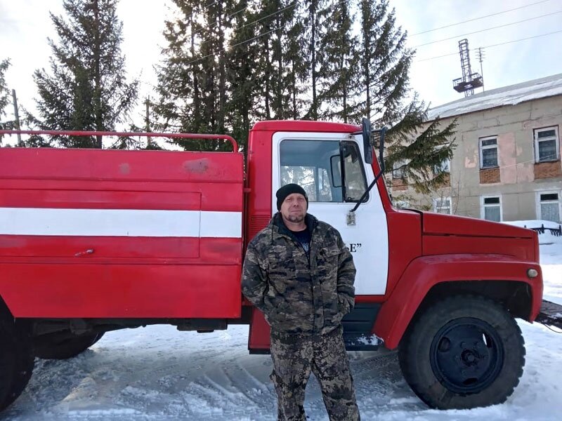 На снимке: Добровольный пожарный Анатолий Руди у пожарного автомобиля.