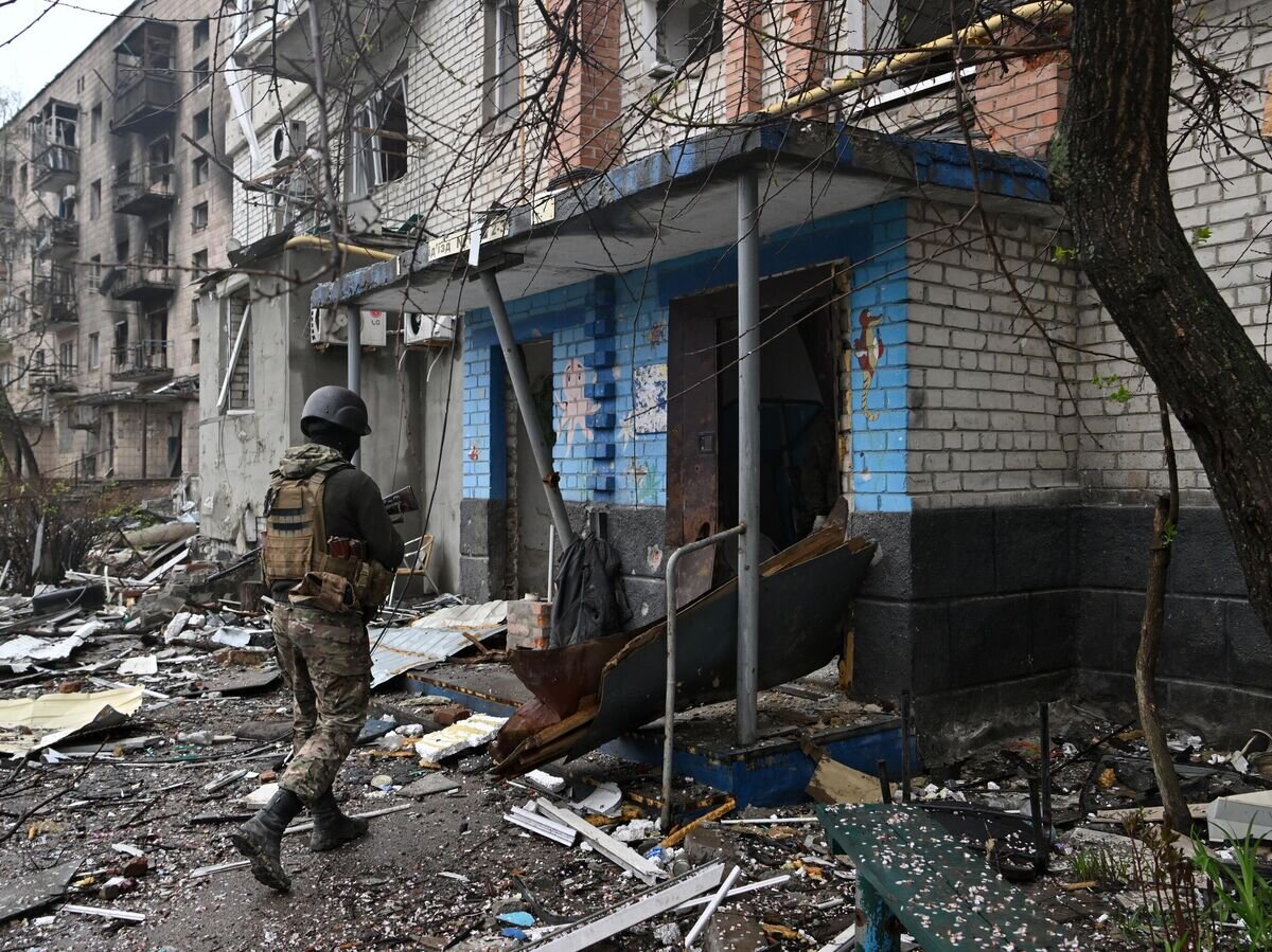    Боец ЧВК "Вагнер" осматривает дома в центре Артемовска© РИА Новости / Евгений Биятов