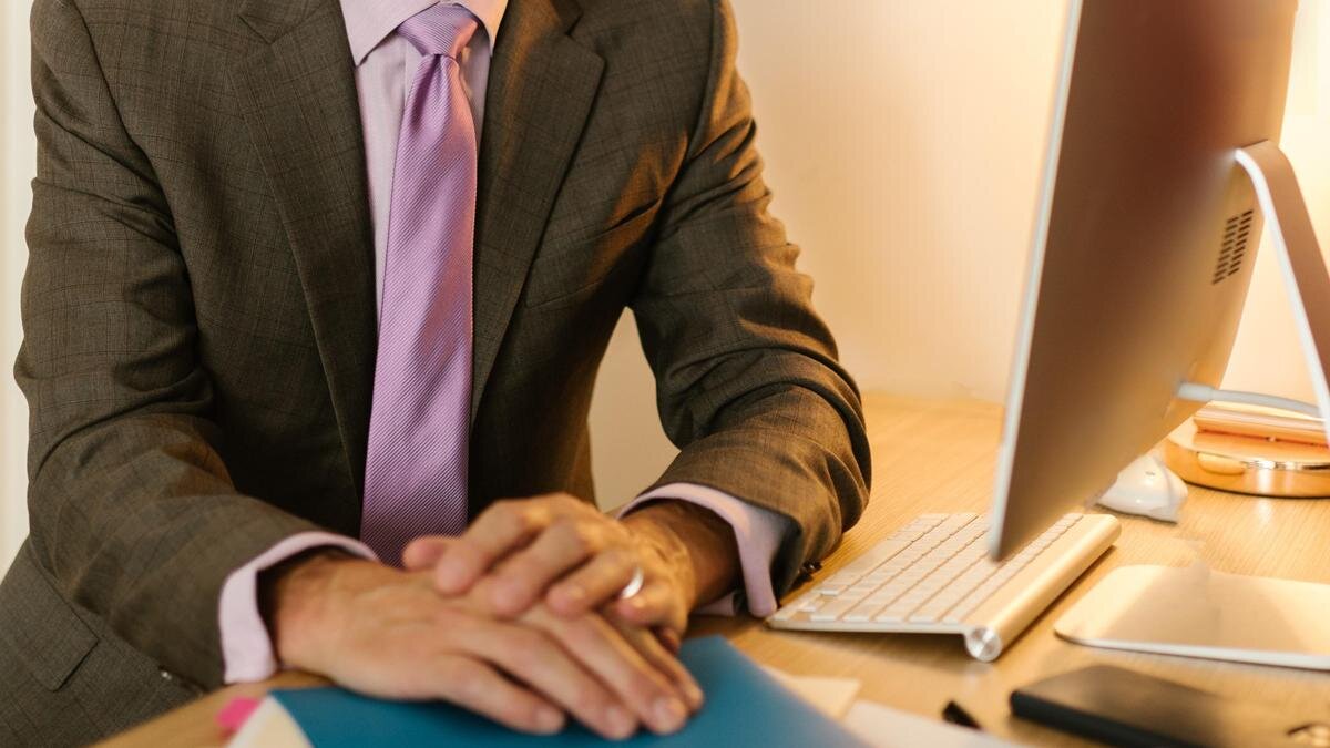    Мужчина в костюме сидит за столом:pexels.com