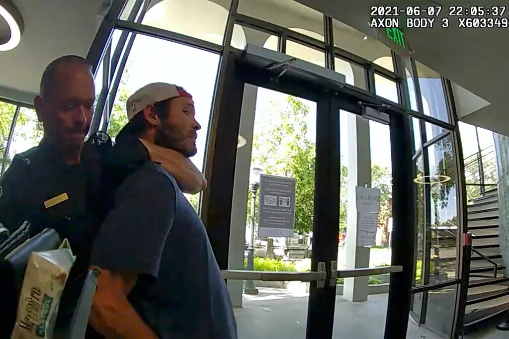 Видеозапись с камеры наблюдения полиции из дела, в котором сотрудника полиции Грили, штат Колорадо, обвинили в использовании удушения при аресте мужчины в июне 2021 года.